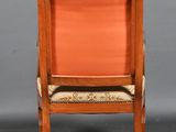 a wooden chair with an orange upholstered seat on a grey background