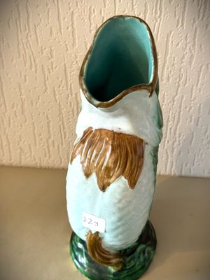 un vase en céramique orné d'un visage marron et blanc