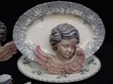 a plate with a statue of an angel on it and a cup and saucer