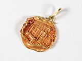 une image représentant un pendentif en or orné d'une illustration d'une ville