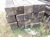 a pile of wood sitting in the grass next to a pile of logs
