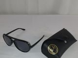 une paire de lunettes de soleil posée sur une table, à côté d'un étui noir