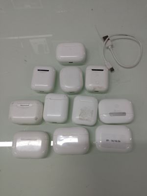 a lot of white apple airpods sitting on a table