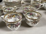 an assortment of porcelain tea and coffee cups and saucers