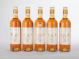 quatre bouteilles de vin sont alignées sur une surface blanche