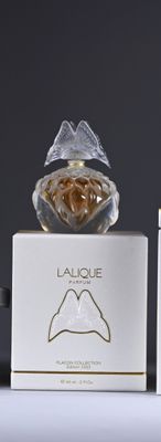 two bottles of perfume sitting next to each other on a table