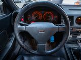 a steering wheel and dashboard of a car in a parking lot