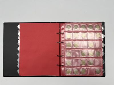 un gros plan sur un livre à la couverture rouge et rempli de pièces de monnaie