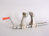 a metal clamp with a red handle on a white surface