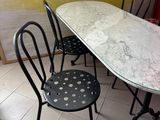 a table and chairs in a room with a yellow wall