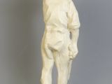 une statue blanche représentant un garçon avec un bol sur la tête