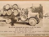 une vieille photo d'un homme debout à côté d'un camion sur la benne duquel sont empilés des fûts