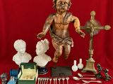 a statue of a child on a table with silverware and other items