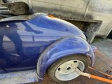a blue car that is being towed by a tow rope