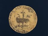 une image représentant une pièce d'or sur laquelle figure une chèvre couchée sur le dos