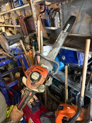 un homme tenant une tronçonneuse dans un garage