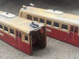 two toy trains sitting side by side on the ground