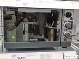 un homme debout devant un micro-ondes dans un magasin
