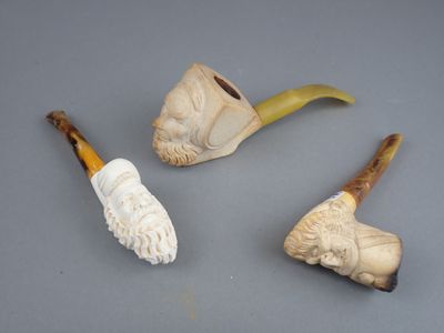 trois types différents de traces de fumée de pipe sur une surface grise