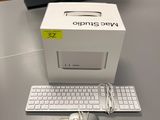 une boîte blanche posée sur une table, avec un clavier et une souris à côté