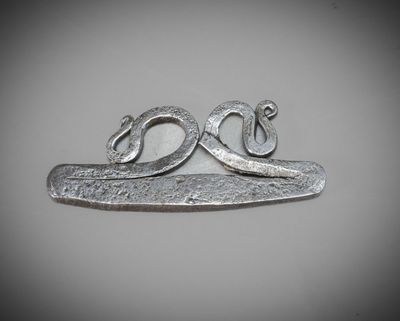 un gros plan d'un objet métallique sur lequel figure un serpent