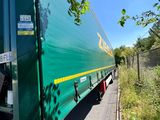 a green semi truck that is parked on the side of the road