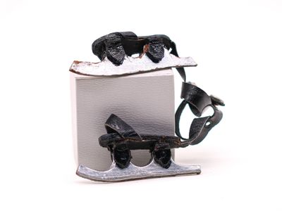 une petite figurine d'ours noir posée sur une boîte blanche