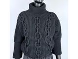 un mannequin vêtu d'un pull noir et d'un pantalon noir