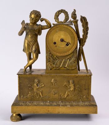 une horloge ancienne en laiton ornée d'une statue représentant une femme tenant un bâton