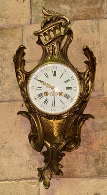 une horloge dorée accrochée au mur d'un immeuble