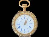 a gold pocket watch with roman numerals on the face
