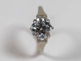 une image d'une bague en diamant sur une surface blanche