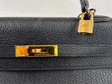 a black leather handbag with a gold lock on the handle