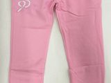 un gros plan sur un pantalon rose posé sur une surface blanche