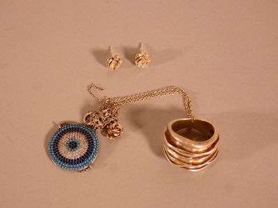 un collier, une bague et une boucle d'oreille posés sur une table