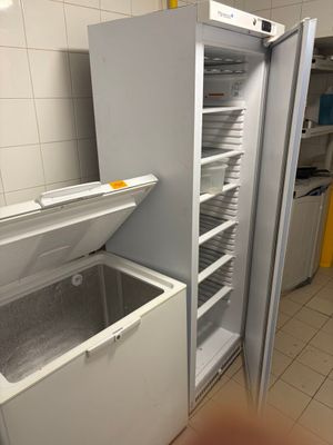 a refrigerator that is open in a kitchen with a lot of dishes