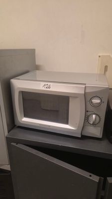 un micro-ondes posé sur un réfrigérateur dans une cuisine