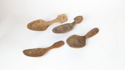 four wooden spoons sitting on top of a white surface