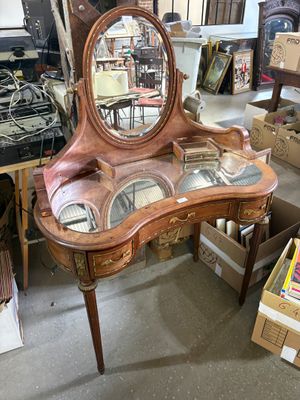 a vanity with a mirror on top of it in a room full of boxes