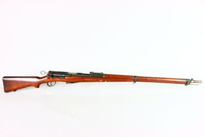 a rifle on a white surface with a white background