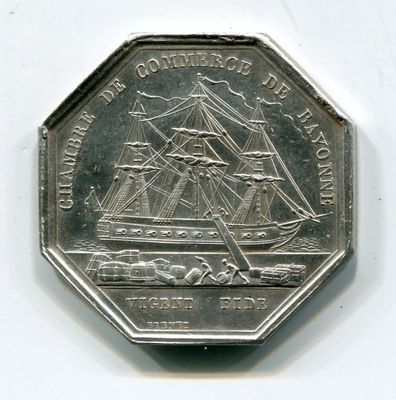une pièce d'argent sur laquelle est représenté un bateau