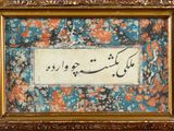 calligraphie arabe dans un cadre doré sur un fond à motifs floraux bleus et orange