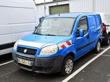 une camionnette bleue garée sur un parking à côté d'une camionnette blanche