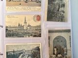 an old photo album with old postcards on a table