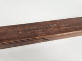 an old wooden box with writing on it sitting on a white surface