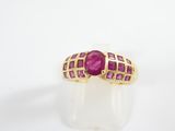 a close up of a gold ring with a ruby stone