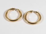 une paire de boucles d'oreilles en or sur fond blanc