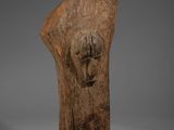 une tête d'homme sculptée dans le bois, posée sur un socle noir
