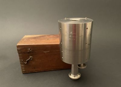 une image représentant un objet métallique avec une boîte en bois en arrière-plan