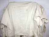 a white shirt hanging on a clothes rack in a room